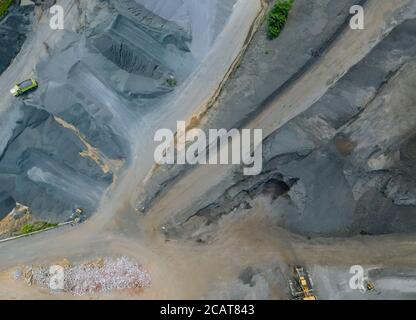 Aerial shot of asphalt and cement factory large piles of construction rocks used for asphalt production heavy machinery ready to work Stock Photo