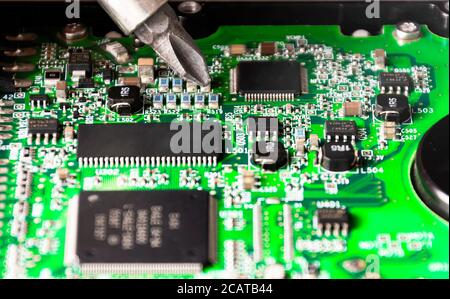 repairing a printed circuit board. Micro technology and repairs. Electronic components and conductors Stock Photo