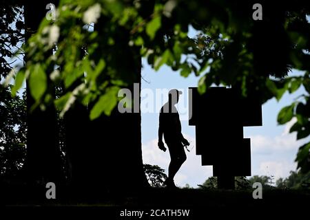 New York City, USA. 08th Aug, 2020. A visitor walks near “Square Forms with Circles” sculpture (by artist Barbara Hepworth) on display at the Storm King Art Center in Mountainville, New York, August 8, 2020. Located in the Hudson Valley, Storm King Art Center sits on 500 acres and is home to one of the largest collections of contemporary outdoor sculptures in the United States. (Anthony Behar/Sipa USA) Credit: Sipa USA/Alamy Live News Stock Photo