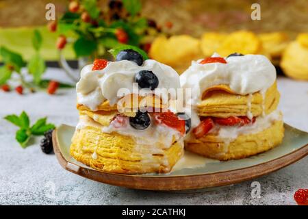 Layered flaky biscuit with berry and whipped cream. Close up. Stock Photo