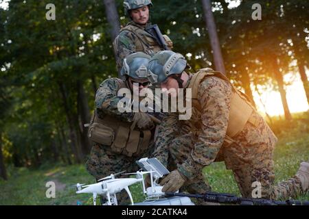 Modern Warfare Soldiers Squad are Using Drone for Scouting and Surveillance During Military Operation in the Forest. Stock Photo