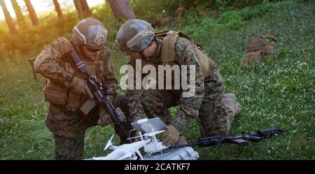 Modern Warfare Soldiers Squad are Using Drone for Scouting and Surveillance During Military Operation in the Forest. Stock Photo