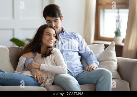 Bonding happy couple relaxing on cozy sofa indoors. Stock Photo