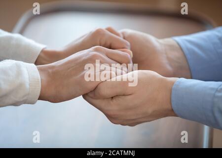 Close up young man holding hands of wife. Stock Photo