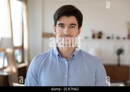 Portrait of smiling young handsome man in living room. Stock Photo