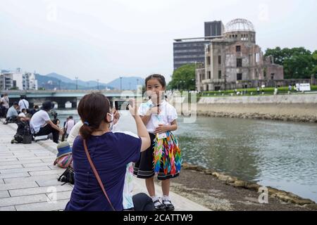 Hiroshima, Japan. 6th Aug, 2020. A girl holding paper cranes for peace poses for a photo near the Atomic Bomb Dome.Hiroshima will mark the 75th anniversary of the atomic bombing which killed about 150,000 people and destroyed the entire city for the first bombing with a nuclear weapon in war. Credit: Jinhee Lee/SOPA Images/ZUMA Wire/Alamy Live News Stock Photo