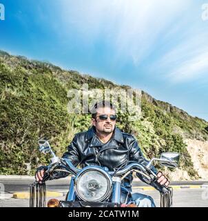 biker on a classic motorcycle on the edge of the road Stock Photo