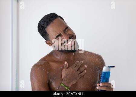 Close up smiling African American young man taking shower Stock Photo
