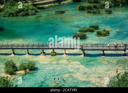 CROATIA, SKRADINSKI BUK - 6/23/2020: Wooden bridge and people bathing in Krka National Park in Croatia. Sunny day, overhead view.  Stock Photo