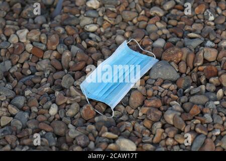 Brighton, UK. 09th Aug, 2020. A face mask discarded on the pebbles - Vast amounts of litter are strewn across Brighton seafront and beach after a busy day at the resort yesterday. Credit: James Boardman/Alamy Live News Stock Photo