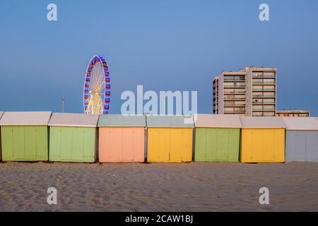 Pastel colored beach cabins and giant wheel on the beach of Berck in France Stock Photo