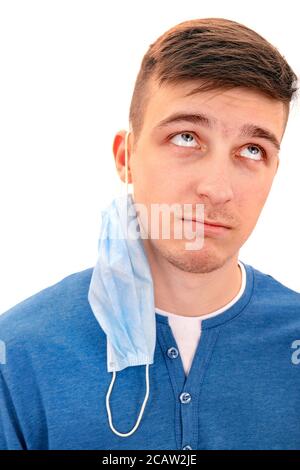 Portrait of Pensive Young Man with a Flu Mask on the Ear Isolated on the White Background Stock Photo