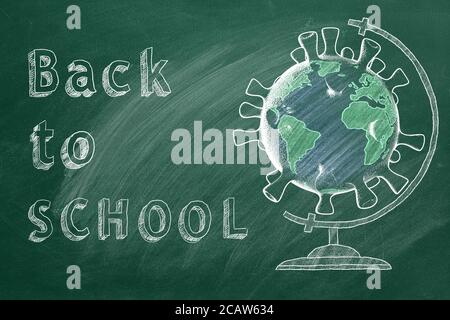 Back to School lettering and globe in shape of coronavirus  are drawn with chalk on a blackboard. Covid-19 concept. Start of the new school year 2020 Stock Photo