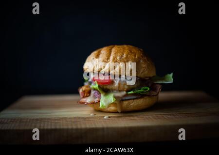 fresh tasty burger on black background. Delicious fresh homemade burger on a wooden table Stock Photo