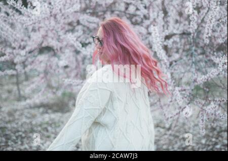 Pink hair female dancing spring blooming trees Stock Photo