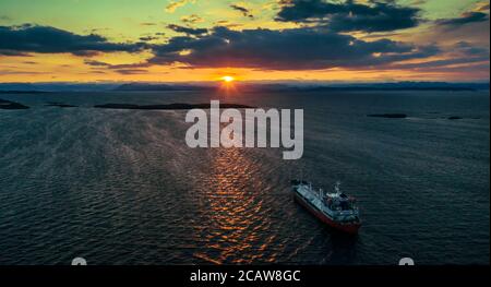 sunrise over the sea bay with a ship at anchor Stock Photo