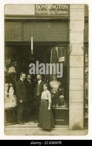 Early 1900's original postcard of staff posing outside a department store. A Bonnington hairdressing saloons sign above the dooer and another sign in the window says Hairdressing and shampooing Saloon, a female mannequin with coiffured hair is seen in the window, U.K, circa 1912 Stock Photo