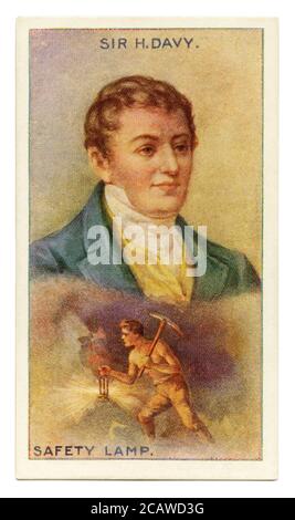 An old cigarette card (c. 1929) with a portrait of Sir Humphry Davy, 1st Baronet (1778–1829) and an illustration of his safety lamp. Davy was a Cornish chemist and inventor. He is best remembered inventing the Davy lamp. In 1815 Davy began experimenting with lamps that could be used safely in coal mines. Dangerous Firedamp (methane mixed with oxygen) was often ignited by the open flames of the lamps then used by miners. Davy's lamp used iron gauze to enclose a lamp's flame to prevent the methane burning inside the lamp from passing out to the atmosphere. Davy refused to patent the lamp. Stock Photo