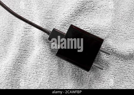a closeup shot of electrical mobile adapter plug isolated on cloth in black & white Stock Photo