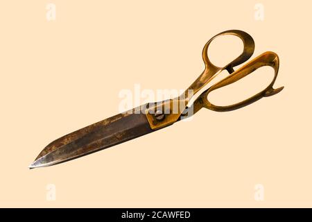 a close shot of rusty tailor scissor isolated on cream color background Stock Photo