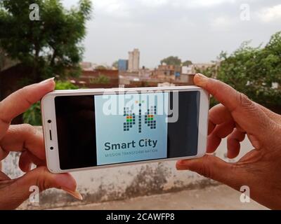 District Katni, Madhya Pradesh, India - 23 May 2020: Smart city government scheme displayed on smart phone screen by indian woman at open background. Stock Photo