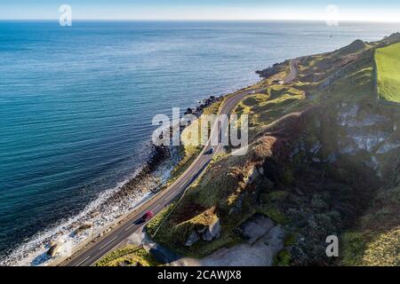 Causeway Coastal Route a.k.a Antrim Coast Road A2 on the Atlantic coast in Northern Ireland. One of the most scenic coastal roads in Europe. Aerial vi Stock Photo