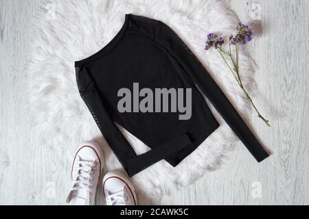 Black sweater on white fur, sneakers. Fashion concept Stock Photo