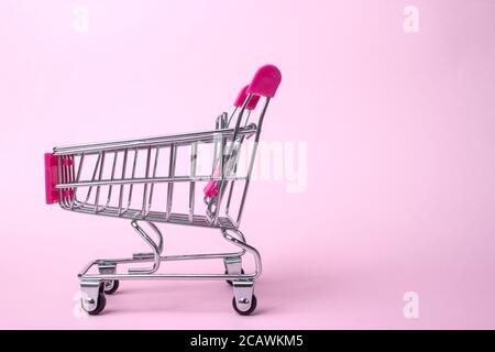 Metallic Small Shopping Cart on Pink background. Black Friday concept. Copy space for text Stock Photo