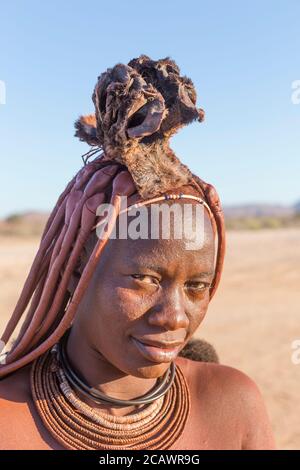 KAMANJAB, NAMIBIA - SEPTEMBER 07, 2015: Unidentified woman from Himba tribe with traditional ornaments and makeup living near Kamanjab. The Himba are Stock Photo