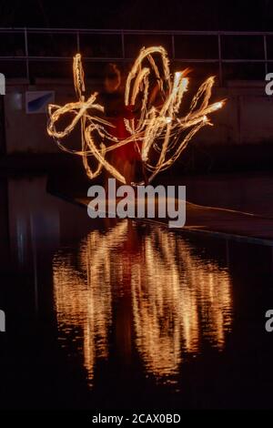 Fire spinning down at marine lake Clevedon Stock Photo