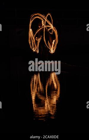 Fire spinning down at marine lake Clevedon Stock Photo