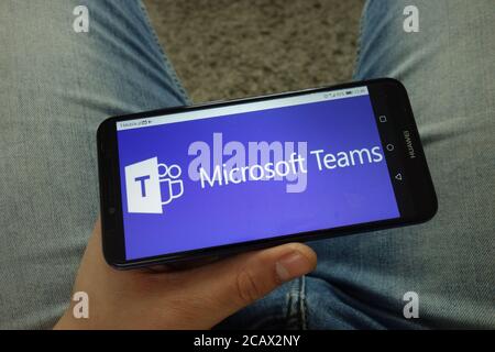 Man holding smartphone with Microsoft Teams communications platform logo Stock Photo