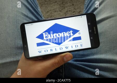 Man holding smartphone with Euronet Worldwide, Inc. company logo Stock Photo