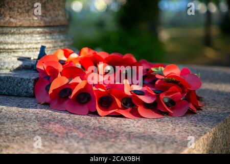 A red poppy wreath laid on a war memorial in remembrance of war dead on remembrance sunday