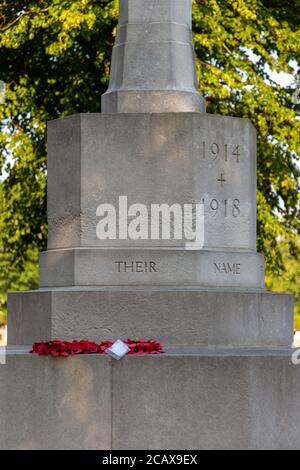 A red Poppy wreath lain on a war memorial that reads their name 1914-1918 a great war memorial on remembrance sunday