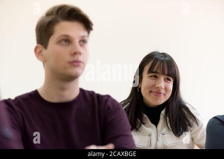 Exams Preparation. Group Of Multi-Ethnic Students Studying Together inside classroom while helping each other. Stock Photo