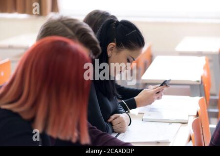 Exams Preparation. Group Of Multi-Ethnic Students Studying Together inside classroom while helping each other. Stock Photo