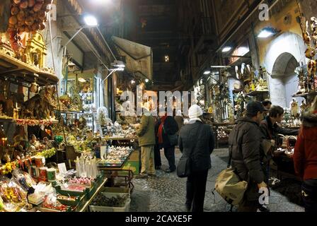 sellers and buyers of nativity scene figurines by night in a typical street market of Naples as of the culture and tradition of Campania Stock Photo