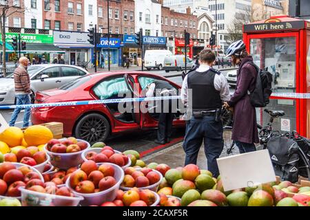 Police officer interviewing a witness to a road traffic incident involving a car in Holloway Road, London, UK in January 2016. Luckily no one was hurt Stock Photo