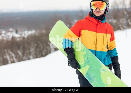 athlete holding a snowboard in hands during winter holiday. Closeup view.free time, spare time, copy space Stock Photo