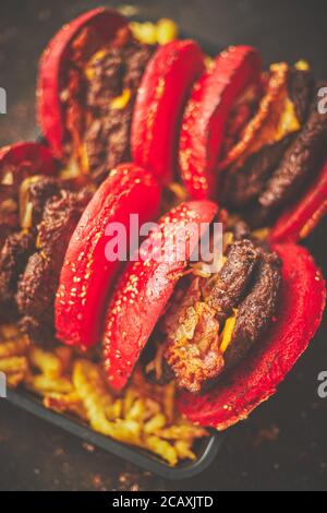 Set of four homemade giant double becon cheese burgers. Served with french fries on wooden board. Stock Photo