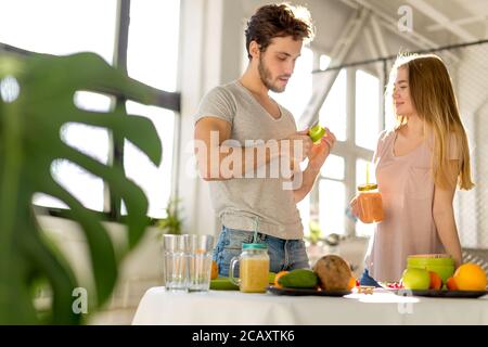 young awesome bearded man is peeling an apple and going to giveit to a girlfriend. close up photo. copy space Stock Photo