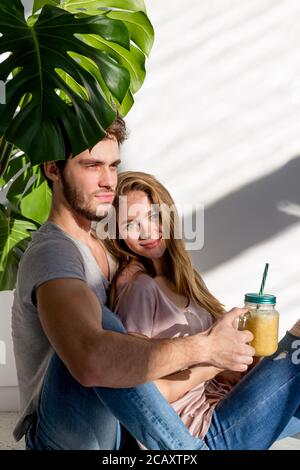 Couple in love drinking smoothie in the hotel. close up photo. relaxed young people indoors Stock Photo