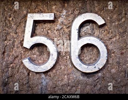 56, number fifty-six, decorative metalic numerals on stone surface. Stock Photo