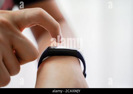 Close up hands of man using smartwatch with copy space. Black digital fitness wrist watch with finger. Stock Photo