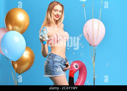 smiling attractive girl rejoicing at rest. close up side view photo. copy space. isolated blue background, studio shot, birthday, woman orginizing pre