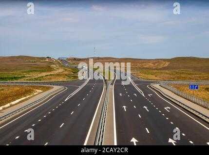 highway in steppe against a blue sky,long road stretching out into the distance Stock Photo