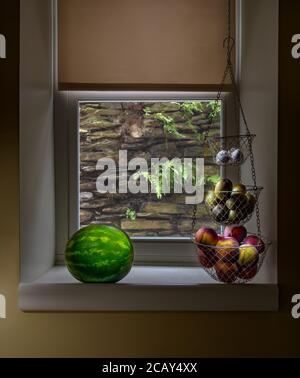 Dramatic light on fresh fruit in kitchen window, USA Stock Photo
