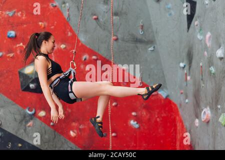young fit girl hanging on the rope, protection concept. side view full length photo Stock Photo