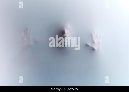 man touching the glass, leaning on it, expressing negative feeling, emotion. man choking with smoke, stifling from want of air. crime concept, murder. Stock Photo